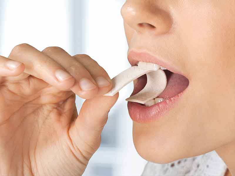 Woman eating a chewing gum, made from gum base