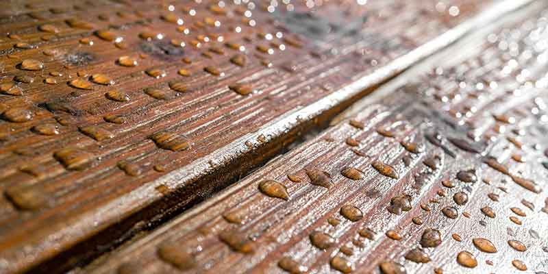 Synthetic wood planks made of granules from natural fiber composites compounding. Synthetic wood terrace planks being produced with raw mass chunks from natural fiber composites compounding systems by BUSS.